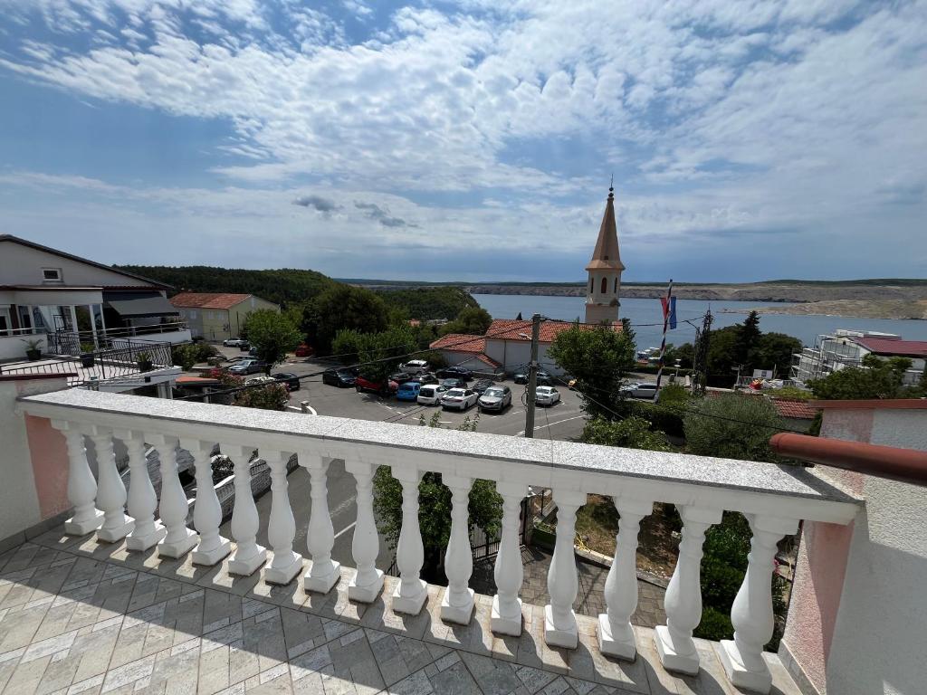 un balcon avec vue sur une ville et une église dans l'établissement Apartmani Rosa, à Jadranovo