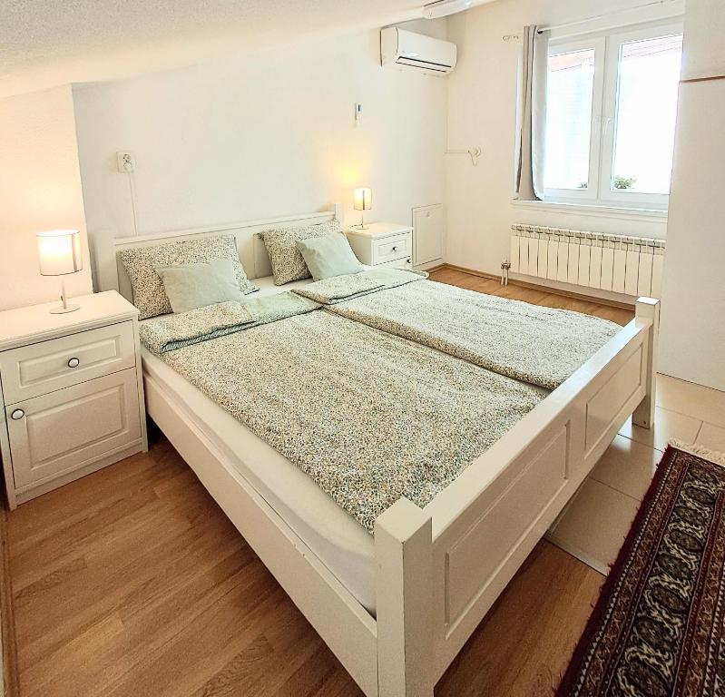 萨拉热窝Sarajevo Cozy Attic - Free Parking的带窗户的房间里有一张白色的大床