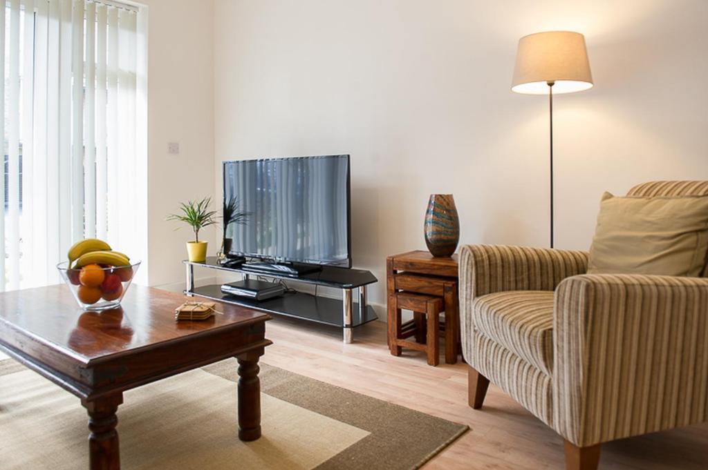 sala de estar con TV y mesa de centro en Stockley Apartments en West Drayton