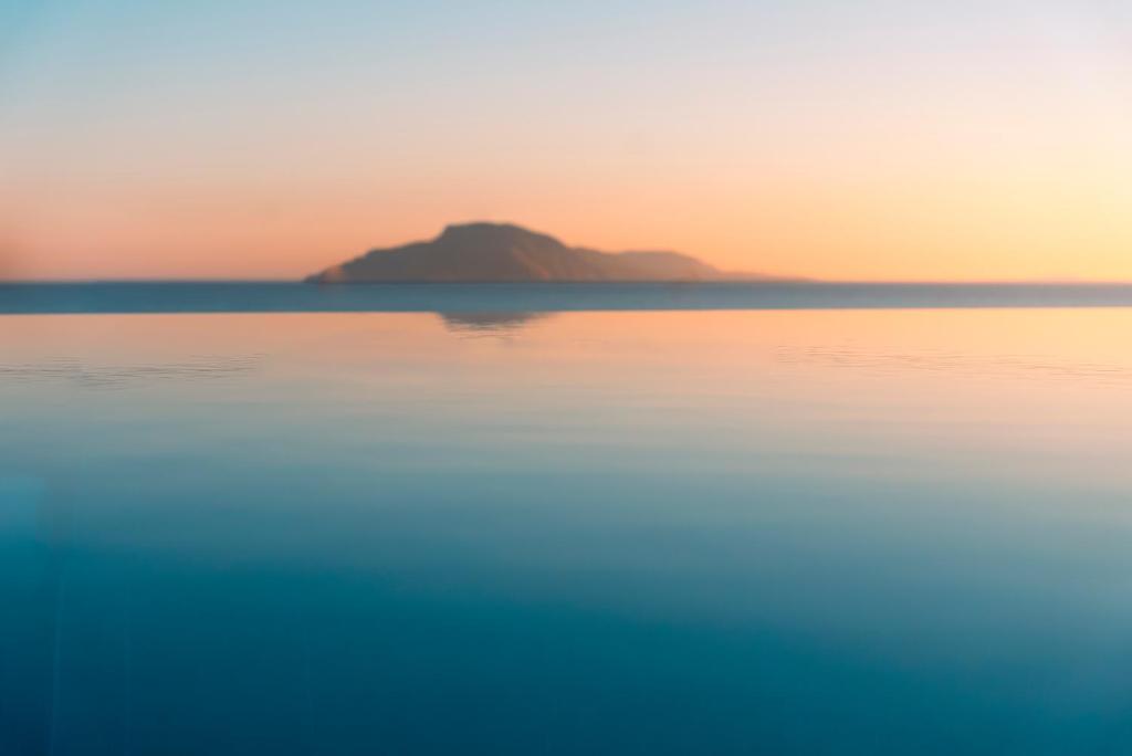 a view of the ocean with a mountain in the background at Alimbali Villas in Karpathos