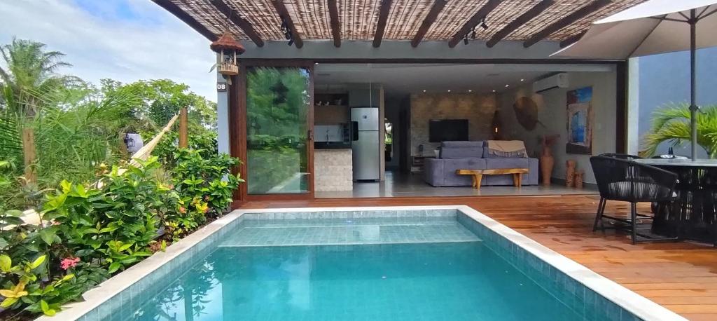 巴拉格兰德Casa Santorini - Barra Grande - Maraú - Vila Kadosh的一座带客厅的房屋前的游泳池