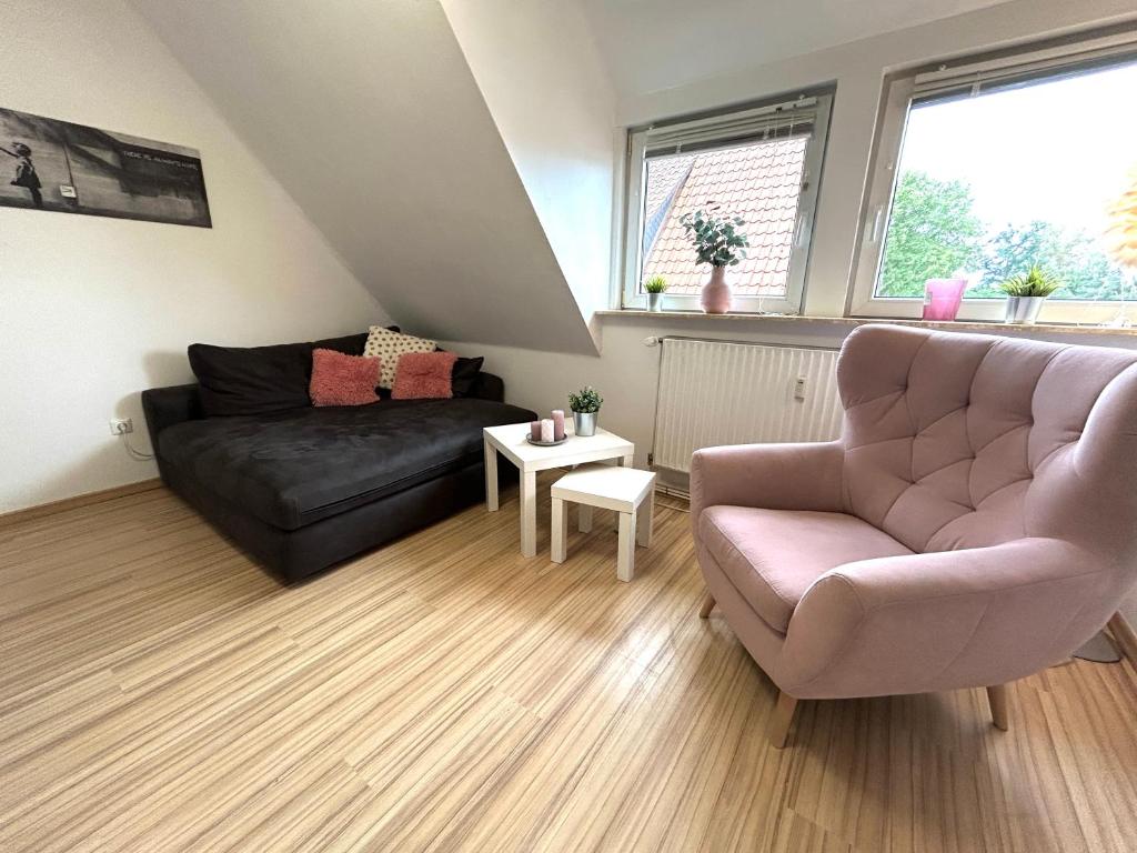 ein Wohnzimmer mit einer Couch und einem Sessel in der Unterkunft Ferienwohnung Wilhelm in Steyerberg