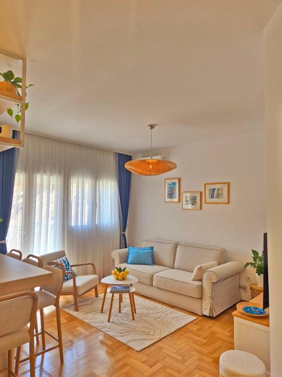 a living room with a couch and a table at Sea Colours Apartment Budva in Budva