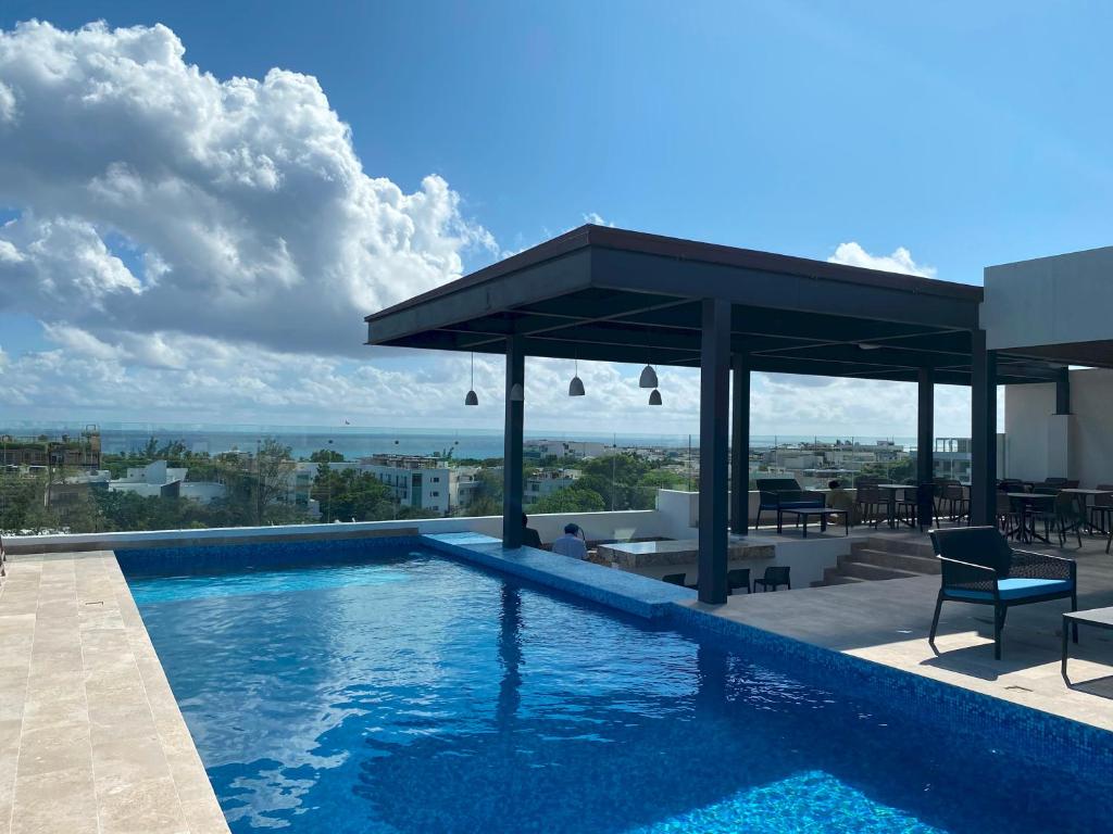 a swimming pool with a gazebo on a building at Always Playa at IPANA in Playa del Carmen
