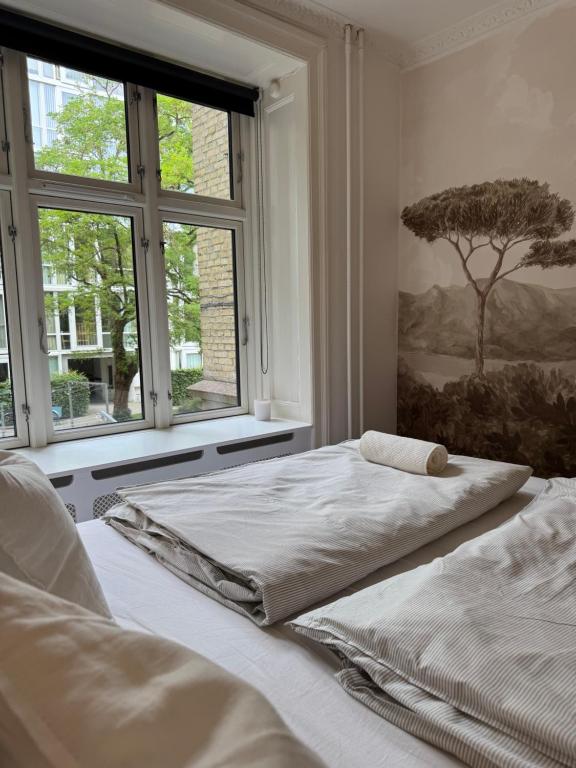 a bedroom with two beds and a window at Stylish Apartment with Rooftop in Trendy Vesterbro in Copenhagen