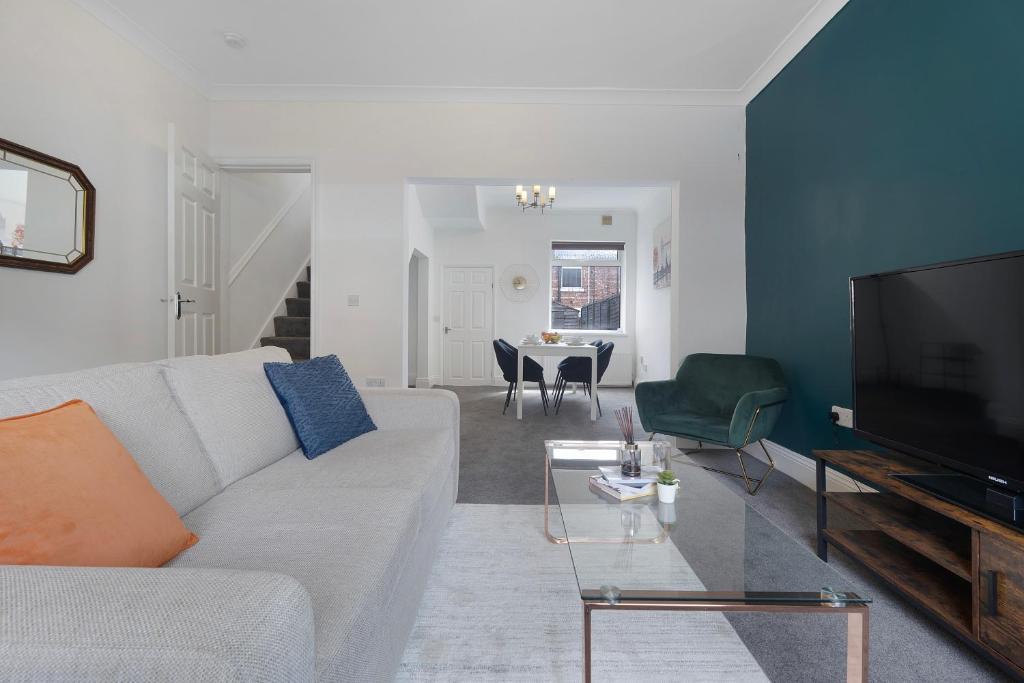 a living room with a white couch and a tv at Frances Terrace Serviced Accommodation - FREE PARKING in Bishop Auckland