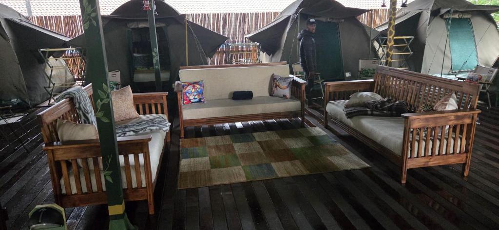 a room with two chairs and a couch on a deck at The Tree Top Village Urban Glamping in St Lucia