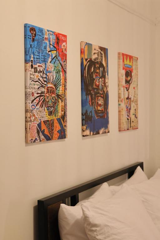 four pieces of art on a wall above a bed at Santa Cruz rooms and hospitality 