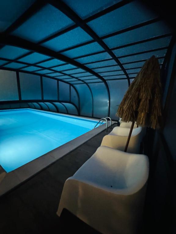a swimming pool with two chairs and a umbrella at Apartamenty Dolce Vita in Ostrowo