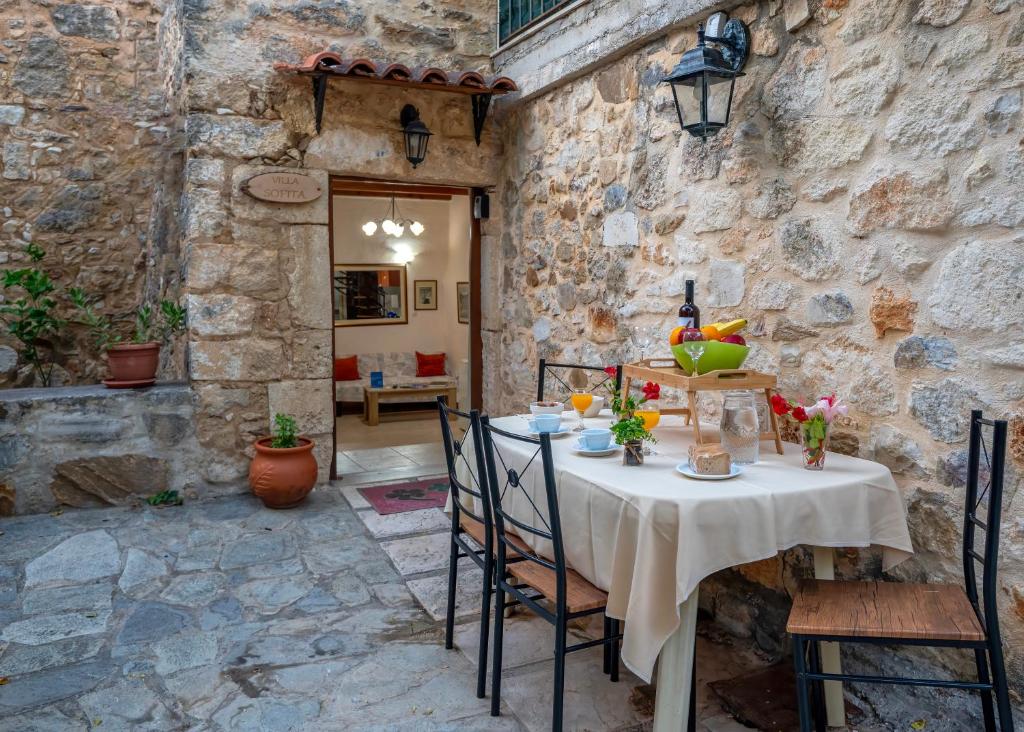 un tavolo in una stanza con un muro in pietra di Villa Sofita with jacuzzi a Maroulás