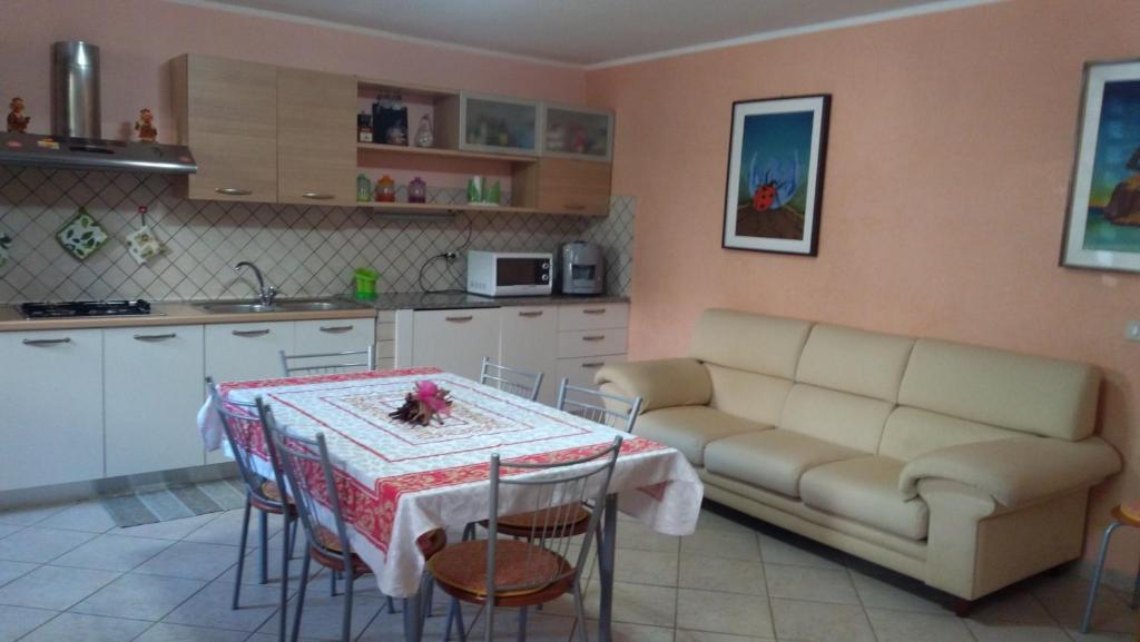 a living room with a table and a couch in a kitchen at Casa Anna in Bosa