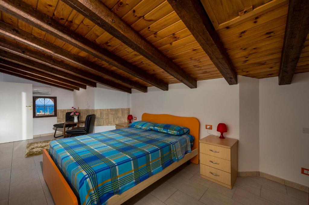 sypialnia z łóżkiem i drewnianym sufitem w obiekcie Casa Vacanze Cappuccini w mieście Castellammare del Golfo