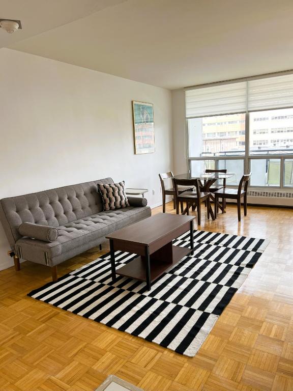 a living room with a couch and tables and chairs at The Charming Downtown Stop in Toronto