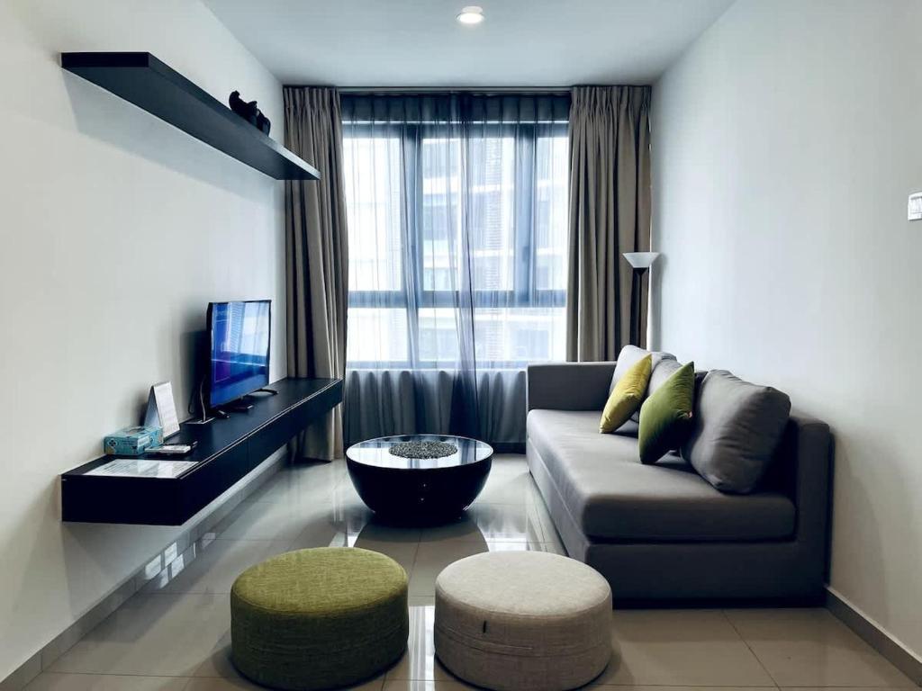 a living room with a couch and a tv at Onyx Homes at i-City - WiFi TV Box and 1 Car Park in Shah Alam