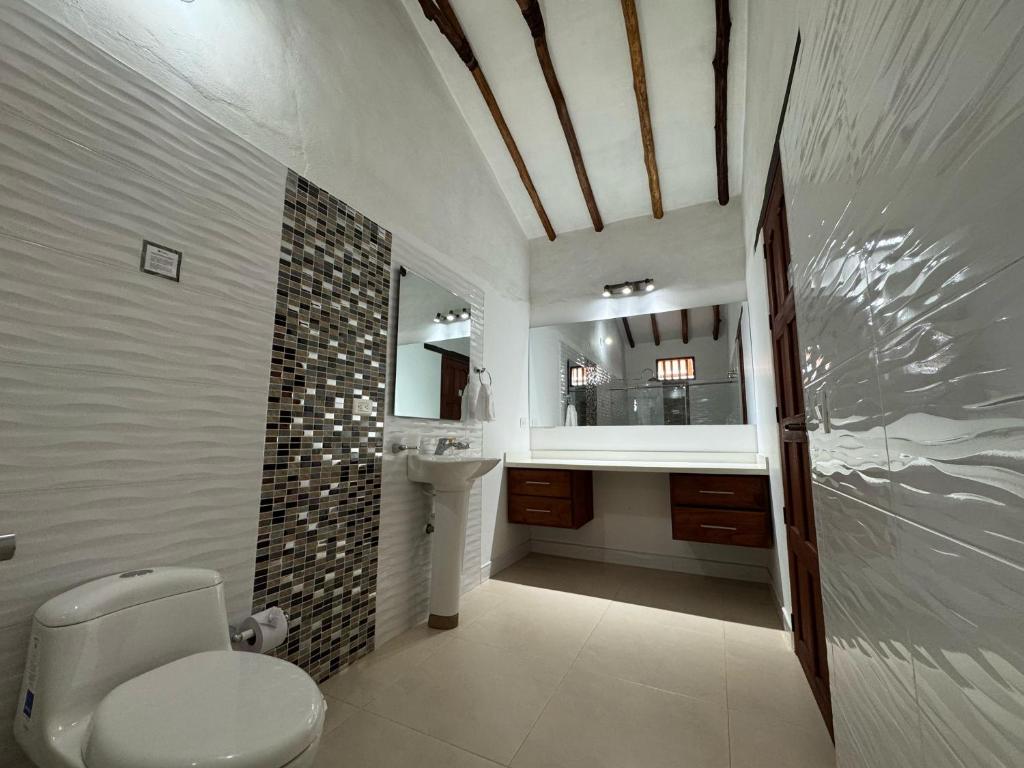 une salle de bain avec toilettes et lavabo dans l'établissement Hotel Palais Barichara, à Barichara