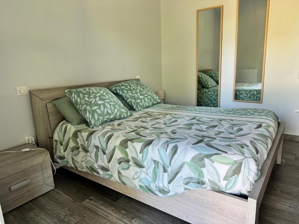 a bedroom with a bed and a mirror at Gîte Relais du Doulay in Saint-Fulgent