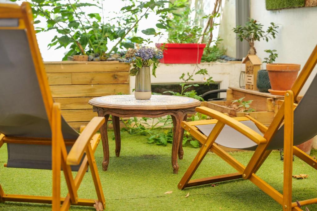 a table and two chairs and a vase with flowers at Studio theme japonais - 2 personnes in Olonne-sur-Mer