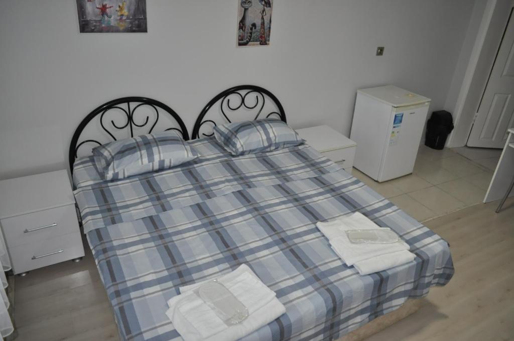 a bedroom with a bed with a plaid blanket at BULUT GAYE Pansiyon in Edirne