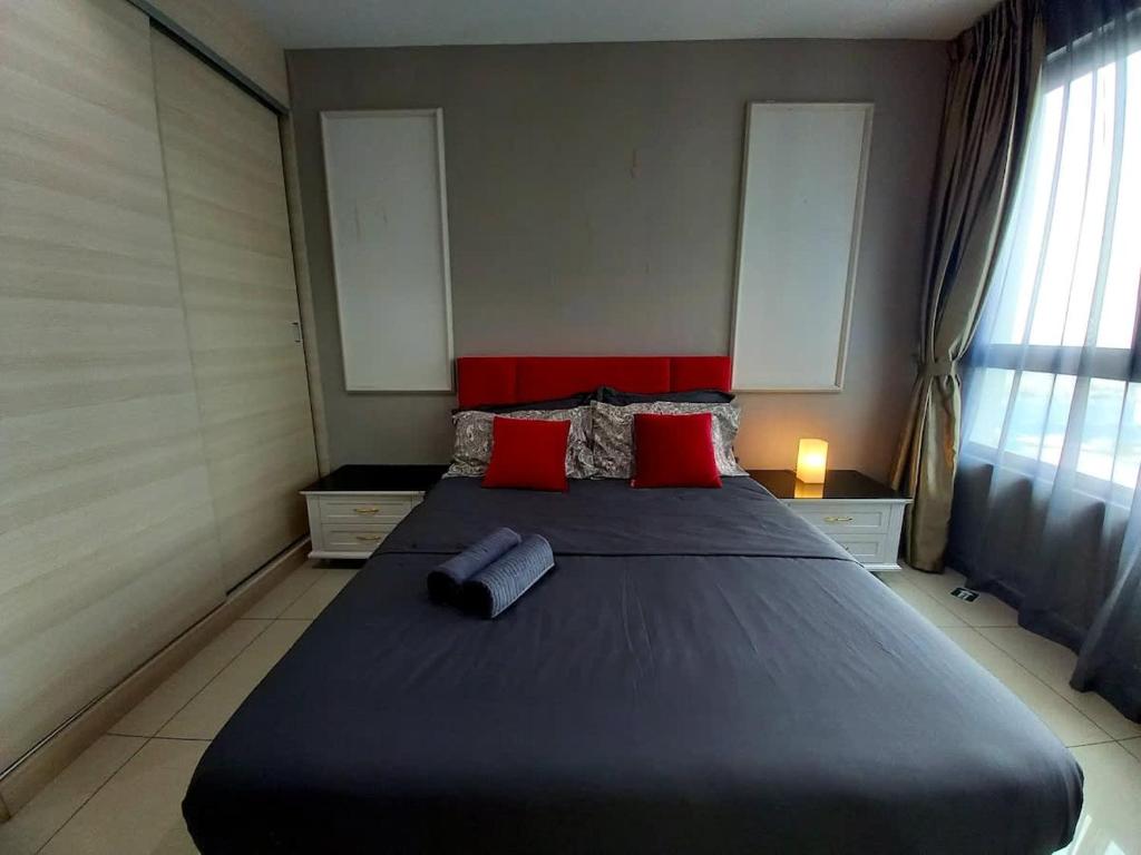 a bedroom with a large bed with red pillows at Phenom Homes at i-City - WiFi TV Box 1 Carpark in Shah Alam