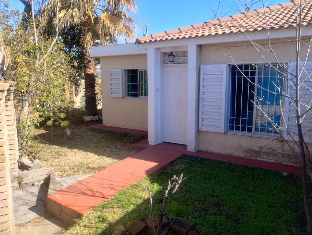 a house with a white door and a yard at Un lugar perfecto in Juana Koslay 