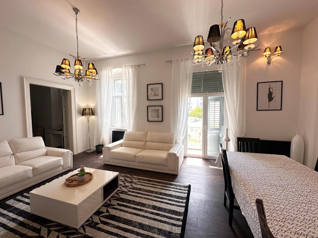 a white living room with a bed and a table at Flanatika Residence Pula in Pula