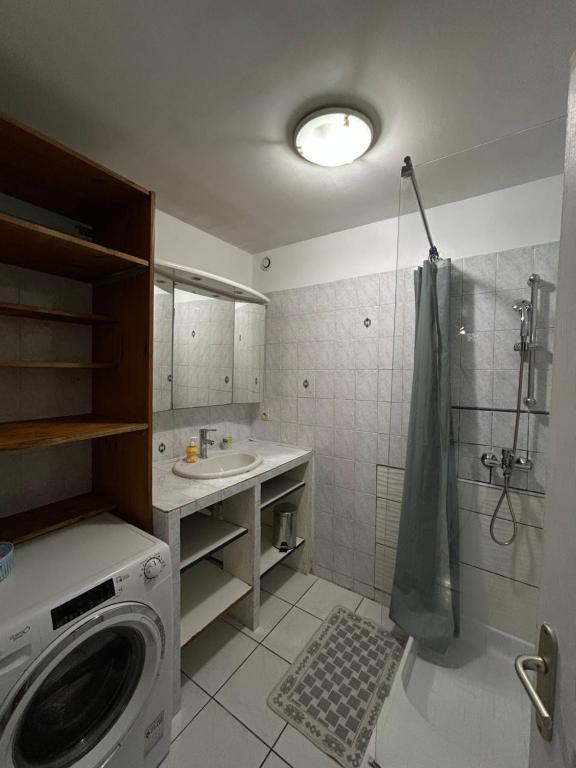 Un baño con lavadora y lavabo. en Charmant bas de villa avec jardin, en La Ciotat