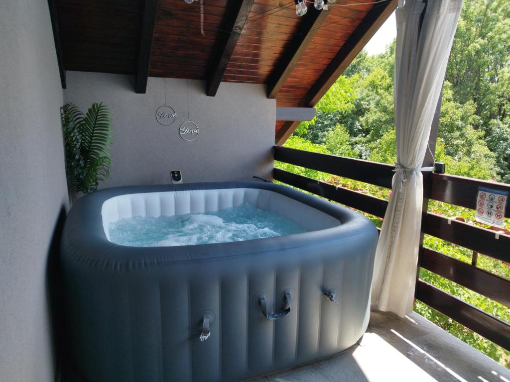 a hot tub on the balcony of a house at Deluxe Apartment with Jacuzzi - PATAR in Rakovica