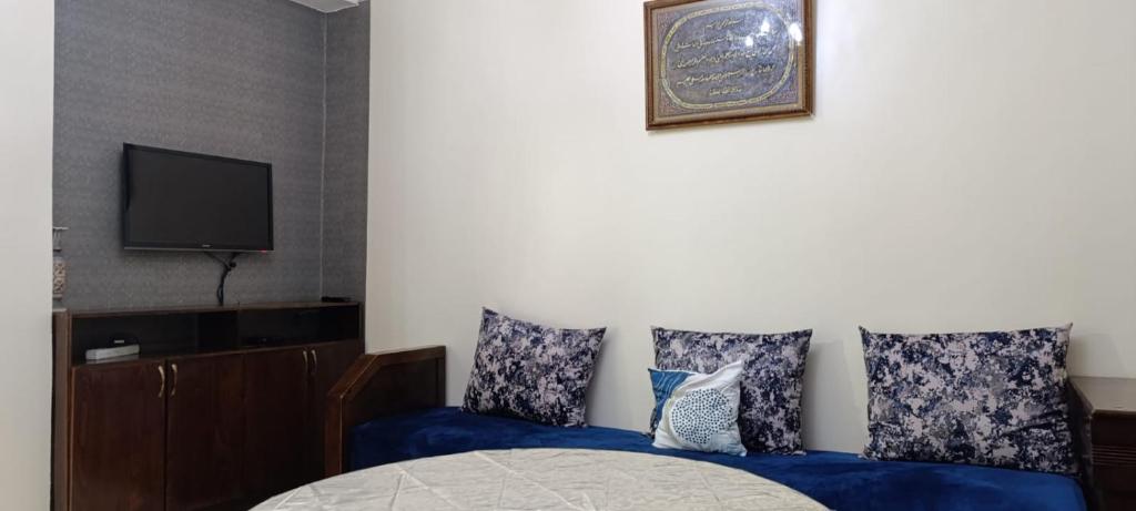 una camera con letto blu e TV di familial simple pratique ad Agadir