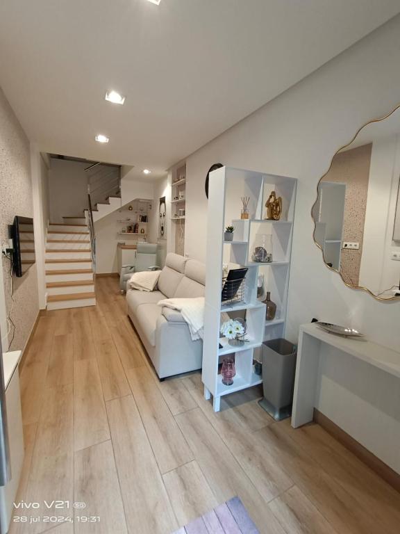 a living room with a bed and a staircase at La Casita de Vane - Casa en el centro con parking privado a unos 250 metros in Cangas de Morrazo