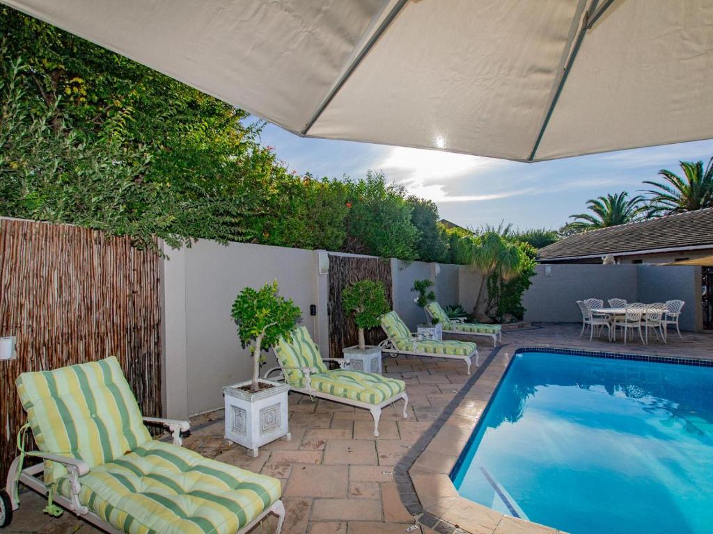 a patio with chairs and a swimming pool at Eikelower Accommodation in Stellenbosch