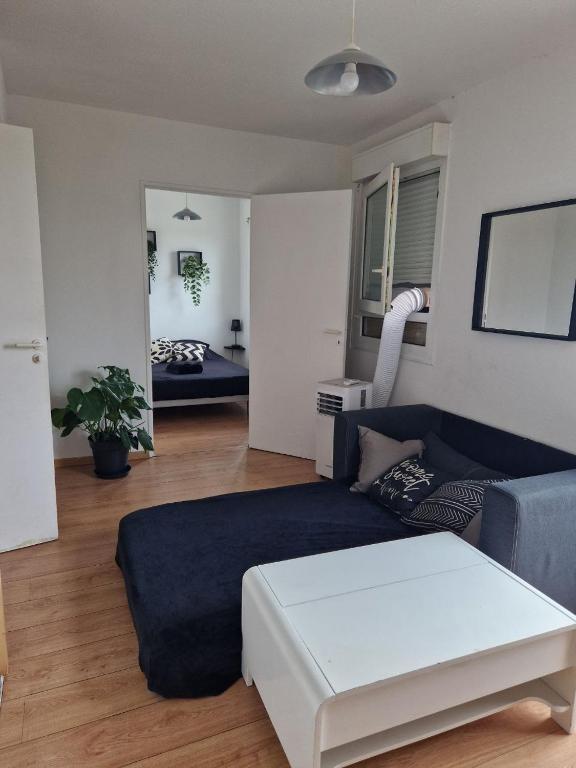 un salon avec un canapé bleu et une chambre avec un lit dans l'établissement Appartement avec vue sur le lez, à Montpellier