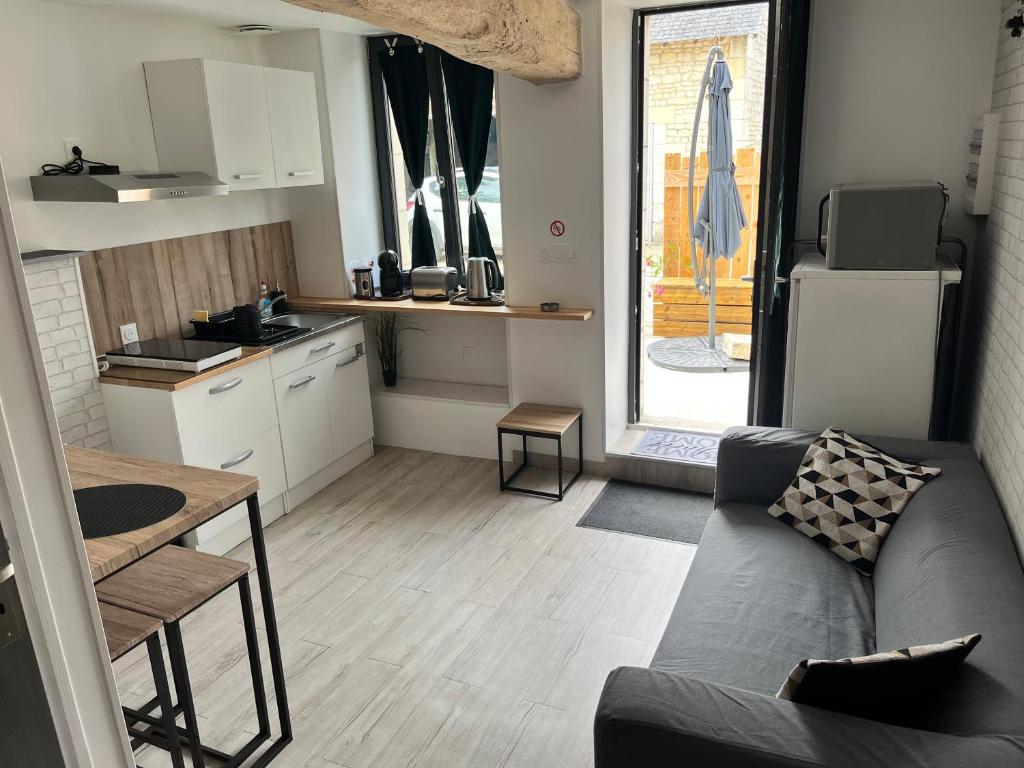 un salon avec un canapé et une cuisine dans l'établissement Gîte carpe Diem, à Ligré