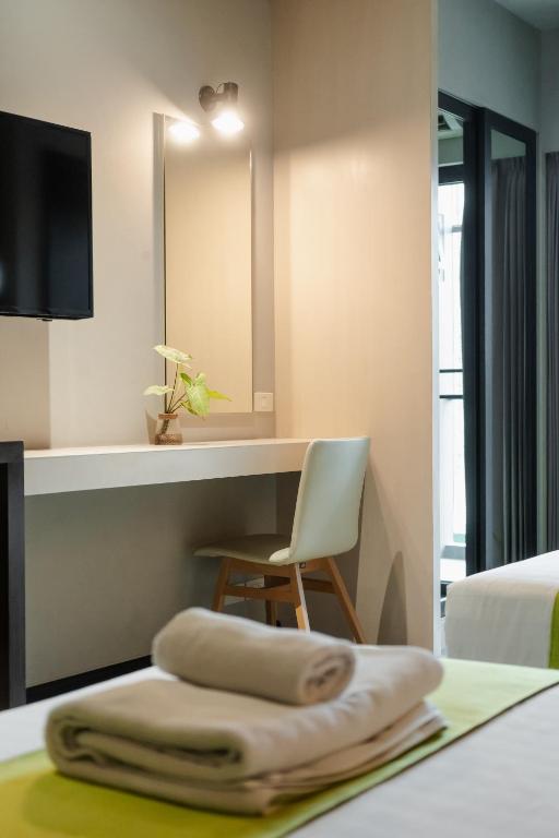 A built-in dressing desk with a chair, mirror and nearby glass opening.