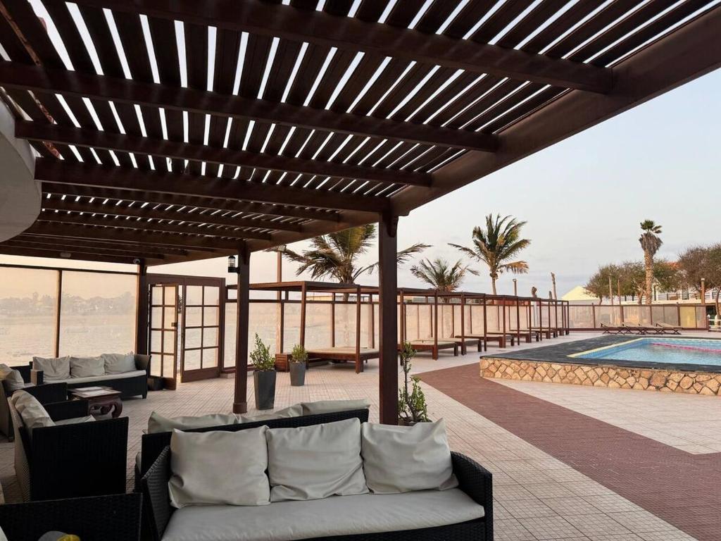 um pátio com sofás, uma piscina e uma pérgola de madeira em Murdeira V31 G by RPG Group em Beirona