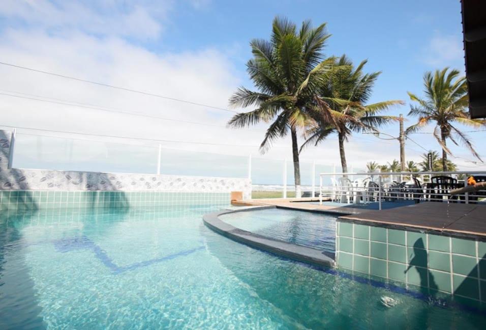 a swimming pool with a view of the ocean at Pousada do Bill in Peruíbe
