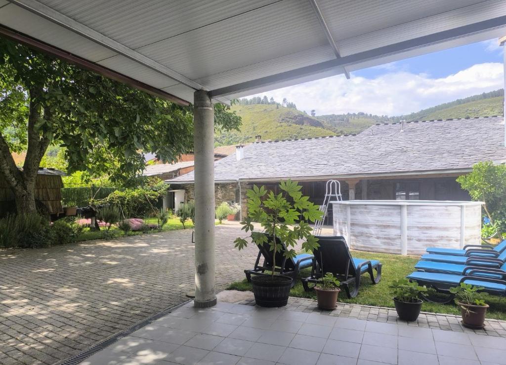 a patio with two chairs and a blue bench at Casa Dos Avós - Alojamento Local in Bragança