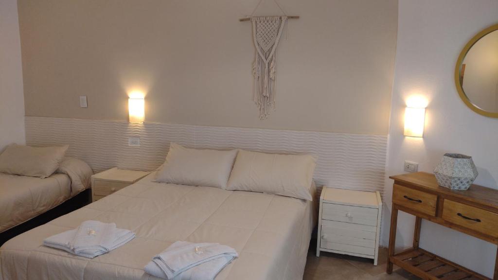 a bedroom with a bed with two towels on it at Hotel Alumine in Villa Cura Brochero