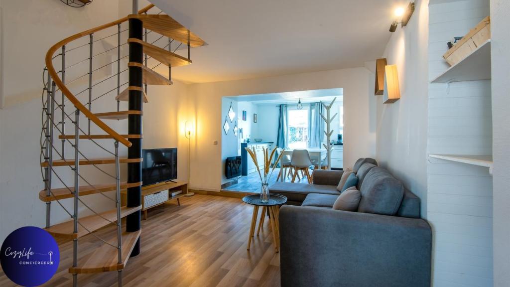 a living room with a couch and a spiral staircase at Le Jardin d'Angély by CozyLife Central Jardin in Niort
