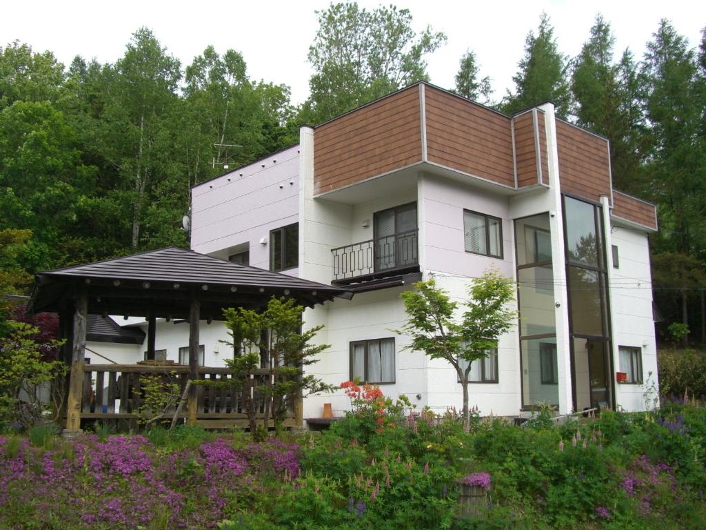 Casa blanca grande con techo marrón en Coro Coro, en Biei