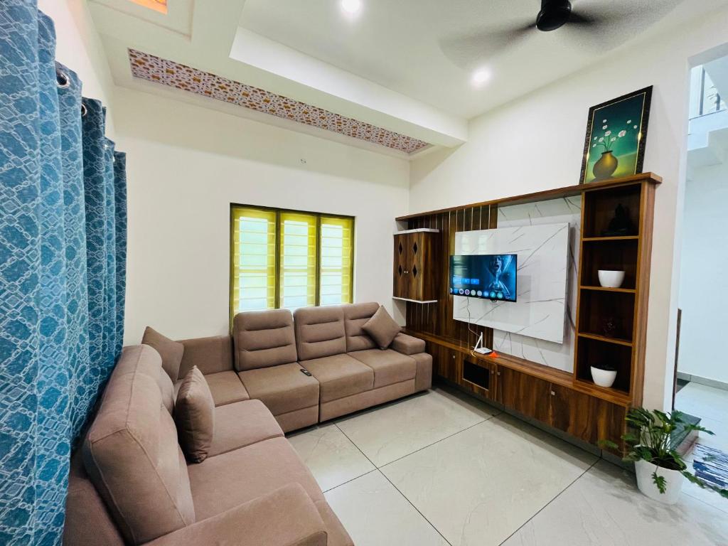 a living room with a couch and a flat screen tv at Cliffnest by Nivara 4BHK Luxury Villa in Varkala in Varkala