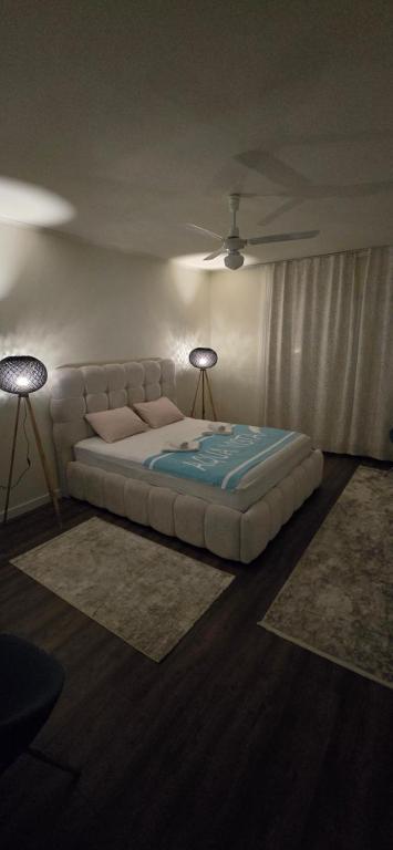 a bedroom with a bed with two lamps and two rugs at Villa Aqua Vista in Mostar