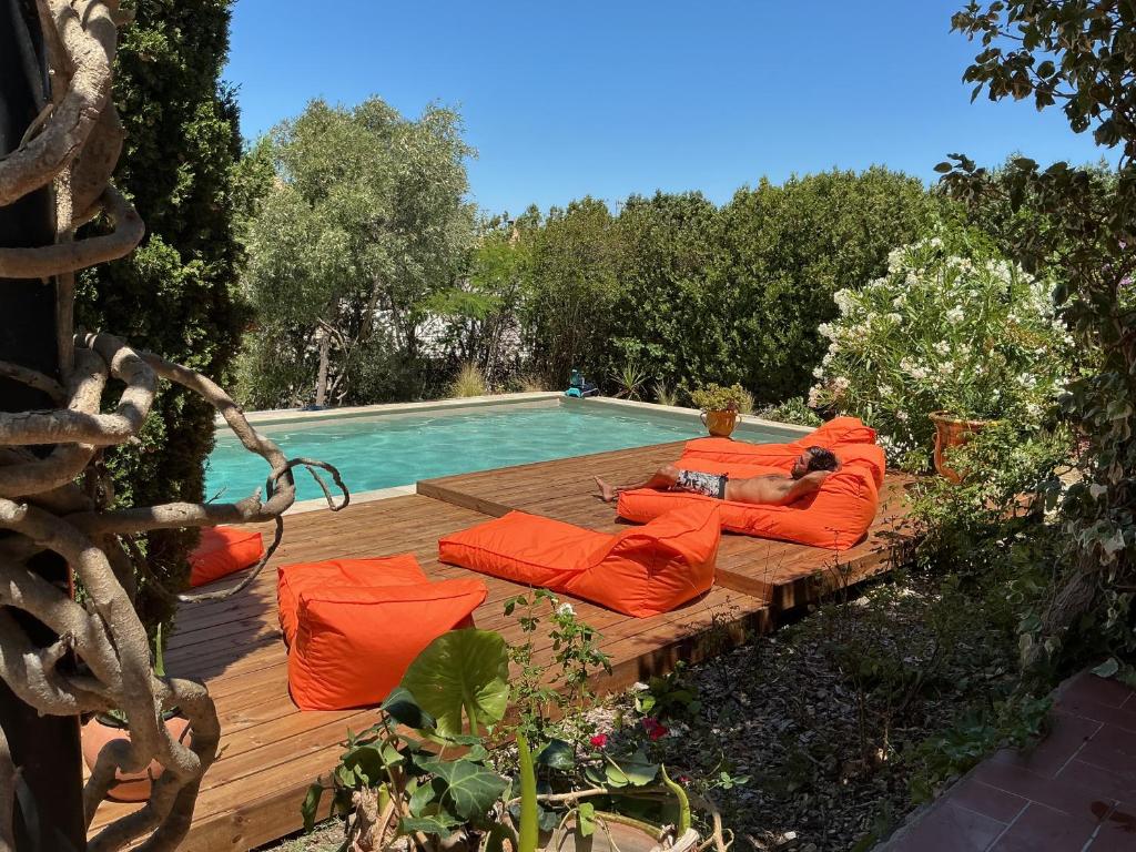d'un homme sur une terrasse à côté d'une piscine dans l'établissement Jolie villa au calme climatisée grande piscine jardin, à Peyriac-de-Mer