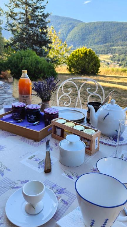 une table avec des assiettes et des bols et un service à thé dans l'établissement Chambres chez l'habitant, à Montbrun-les-Bains