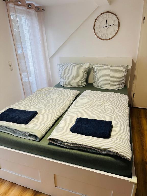 two beds in a room with a clock on the wall at Apartment mit Balkon an der Mosel in Koblenz-Güls in Koblenz