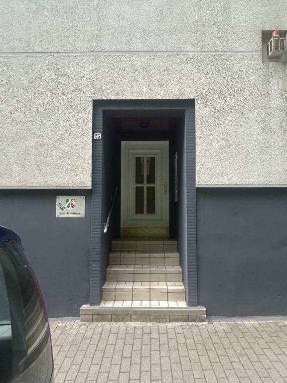 a hallway with a yellow door and stairs in a building at Gemütliche Ferienwohnung - voll ausgestattet, zentral aber ruhig ! in Wuppertal
