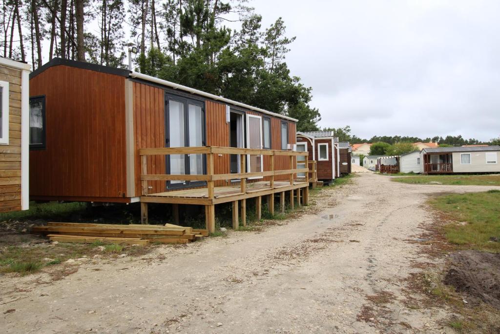 eine Reihe winziger Häuser auf einer unbefestigten Straße in der Unterkunft Land's Hause Bungalows par La Conciergerie Française Emplacement S6 in Pataias