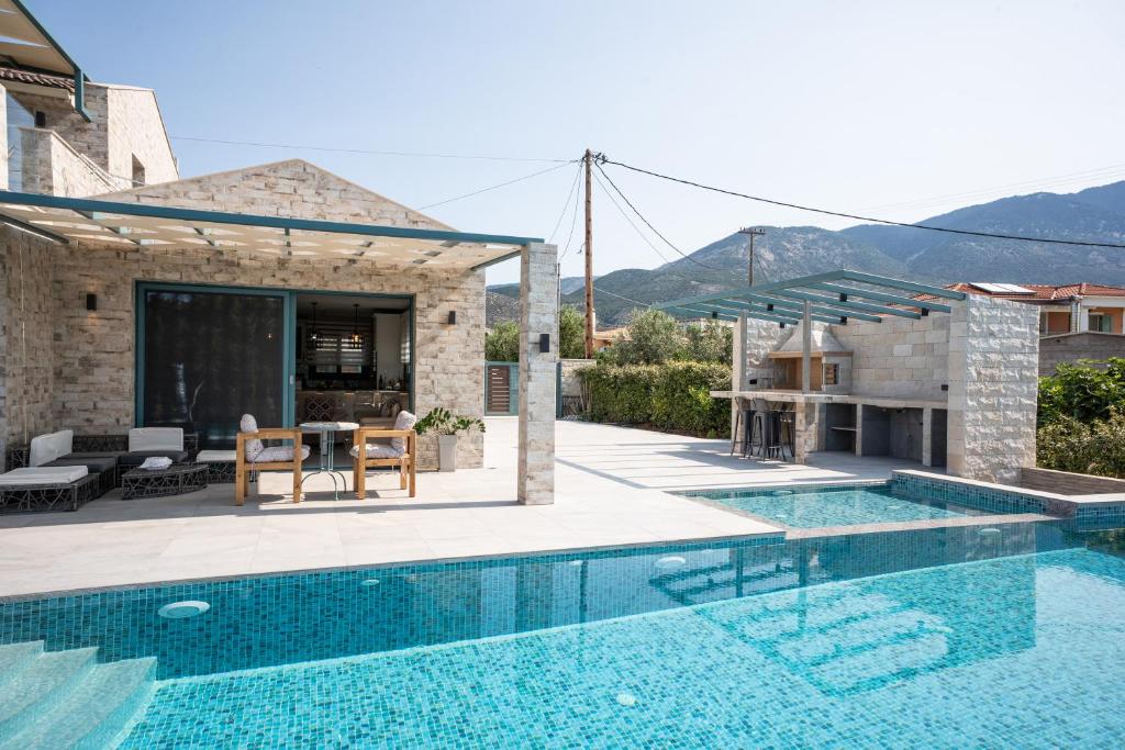 a villa with a swimming pool and a patio at Villa Prestige Karavados in Karavadhos
