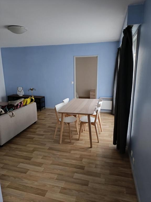 a dining room with a table and a couch at Beau T2 hyper centre face à la gare in Lille