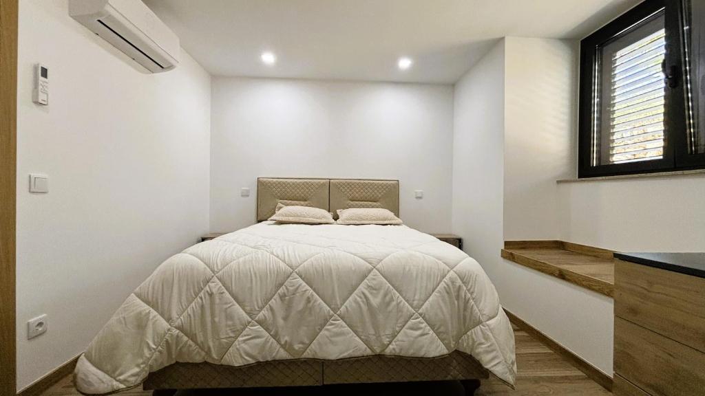 a bedroom with a bed in a white room at As Casas do Penedo da Moura in Arcos de Valdevez