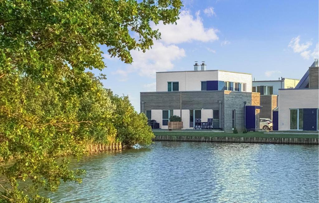 ein Haus neben einem Fluss mit einem Gebäude in der Unterkunft Ocean's Twenty-One in Tossenserdeich